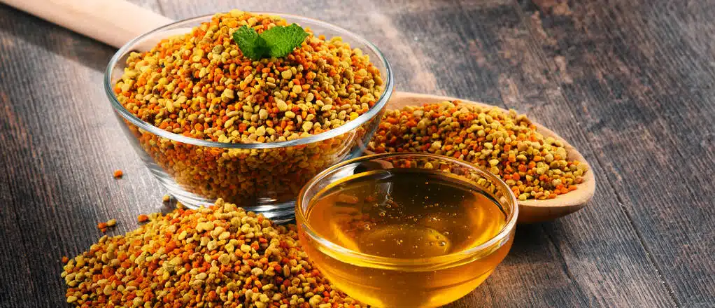 Bowls with bee pollen and honey on kitchen table